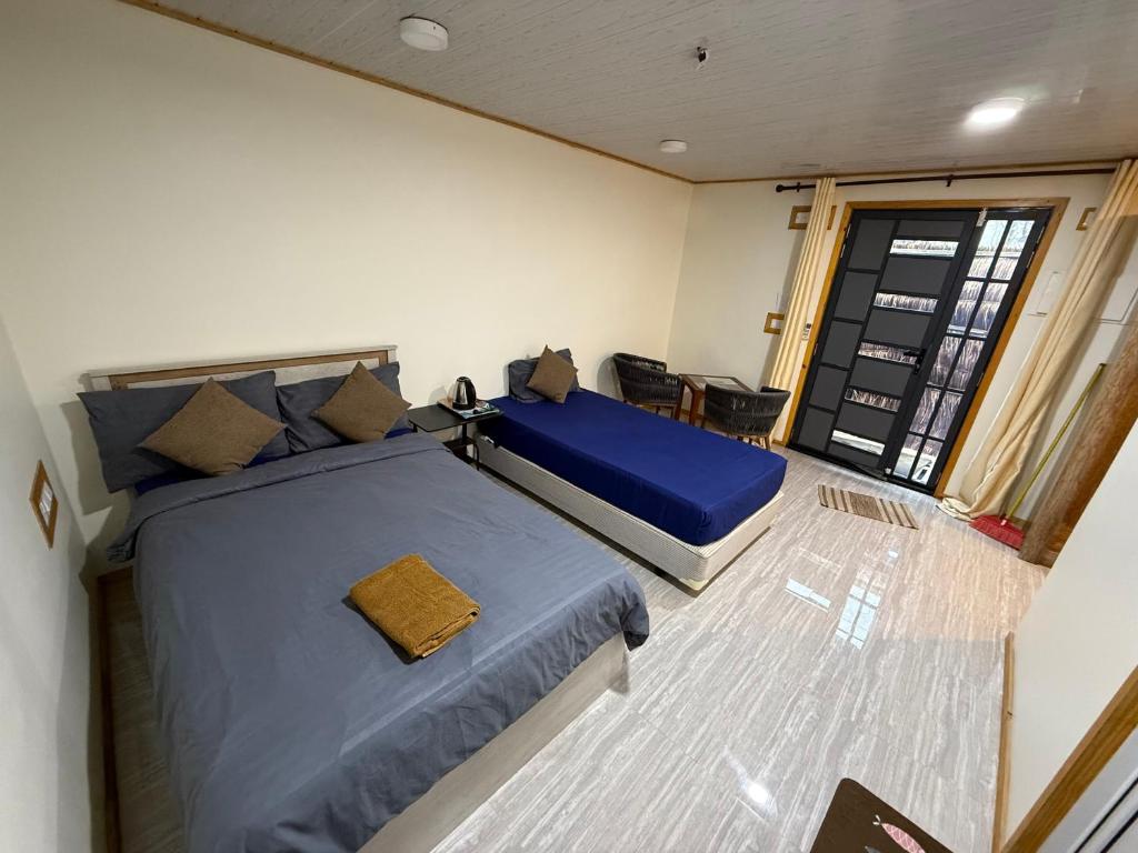 a bedroom with a large bed with blue sheets at Rashuthere Maldives in Rasdu