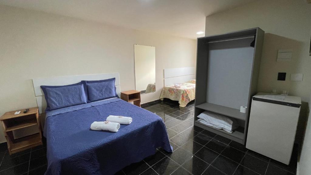 ニテロイにあるCaminho de Itacoatiaraのベッドルーム1室(ブルーベッド1台、タオル付)