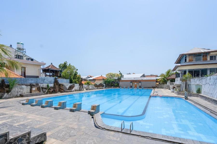 a large swimming pool with blue water at Maha Jaya Hotel Bali in Denpasar