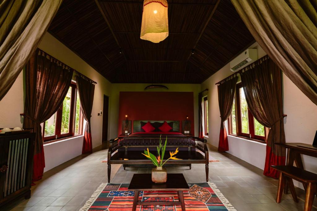 une chambre avec un lit dans une pièce avec des fenêtres dans l'établissement Thala Tra Vinh, à Trà Vinh