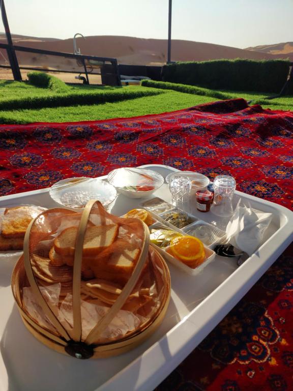 a tray with a basket of food on a table at Private VIP Tent in the Desert in Ḩawīyah