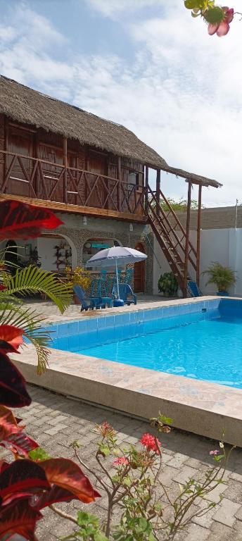 a resort with a swimming pool and a building at Hostal Villa Brisa in Ballenita