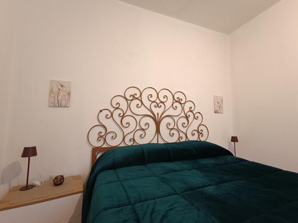 a bedroom with a green bed with a metal headboard at Etna Garden Francesca in Presa