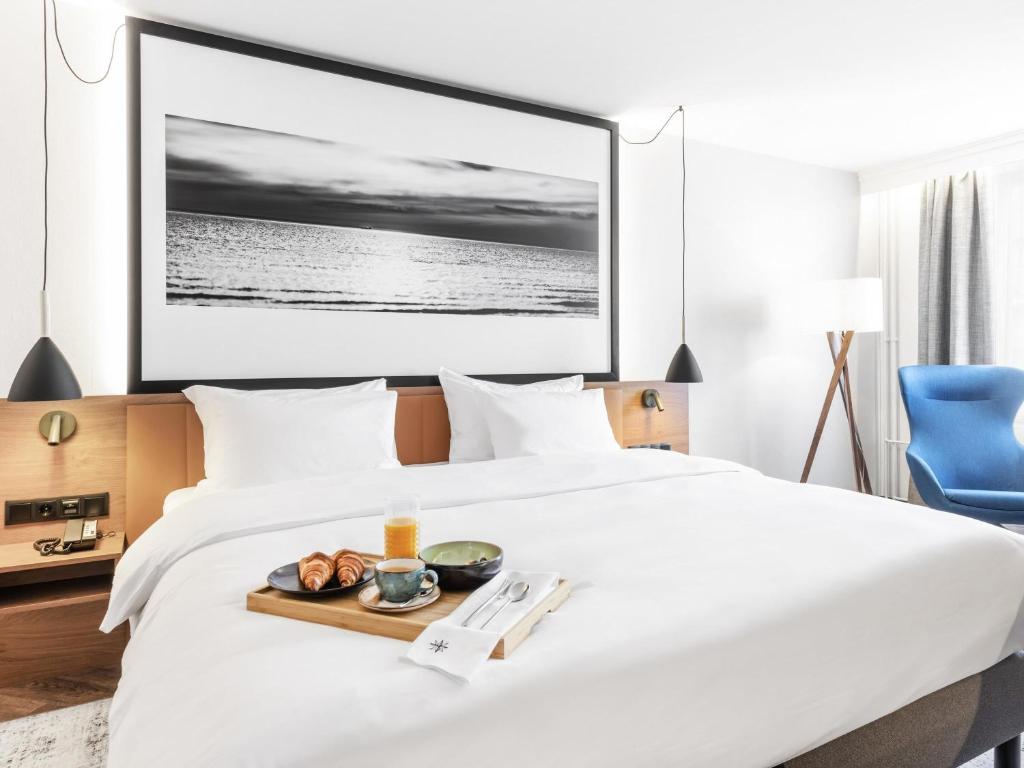 a hotel room with a tray of food on a bed at MERCURE KLAIPEDA CITY HOTEL, Meetings, Events, Restaurant & Bar - Accor Group, Pet Stay FREE in Klaipėda