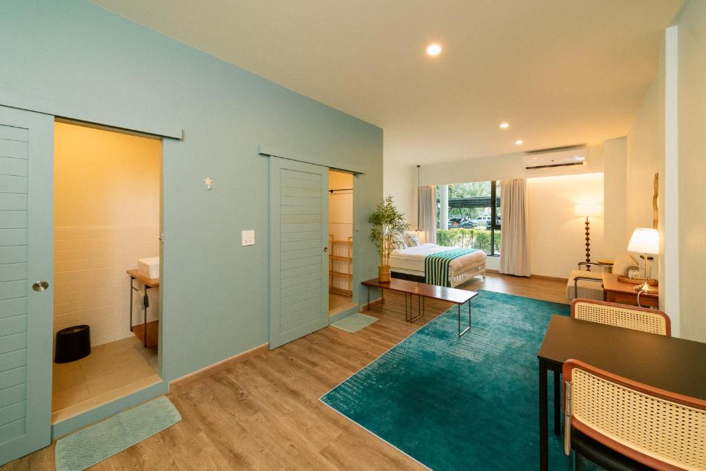 a room with a bedroom and a bed and a table at Nautical Home & Seashell House B&B in Khao Lak