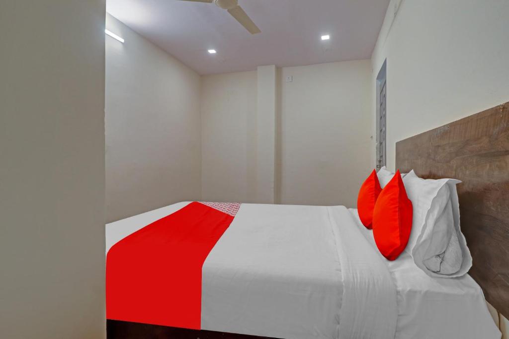 une chambre avec un lit blanc avec des oreillers rouges dans l'établissement Hotel O R Square Bn Reddy, à Hyderabad