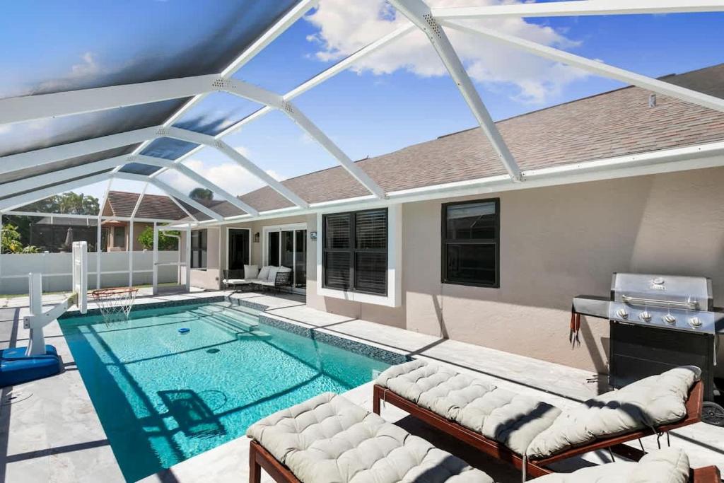 a swimming pool with a large glass ceiling at Marco Island Beach Home - Heated Pool & Spa in Marco Island