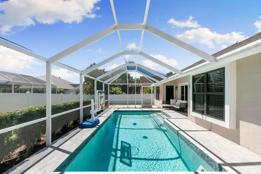 an indoor swimming pool with a pergola and a house at Marco Island Beach Home - Heated Pool & Spa in Marco Island