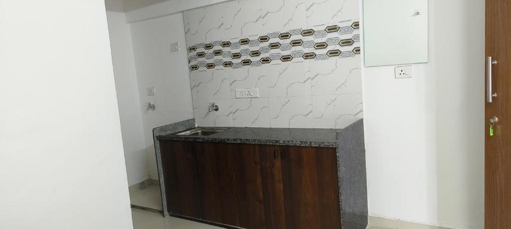 uma cozinha com um balcão com um monte de garrafas de vinho em Namo Guest House em Daman