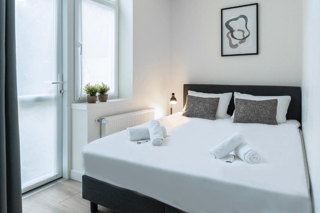Una cama blanca grande en una habitación con ventana. en Fresh And Equipped Apartment Near Hotspots, en Eindhoven