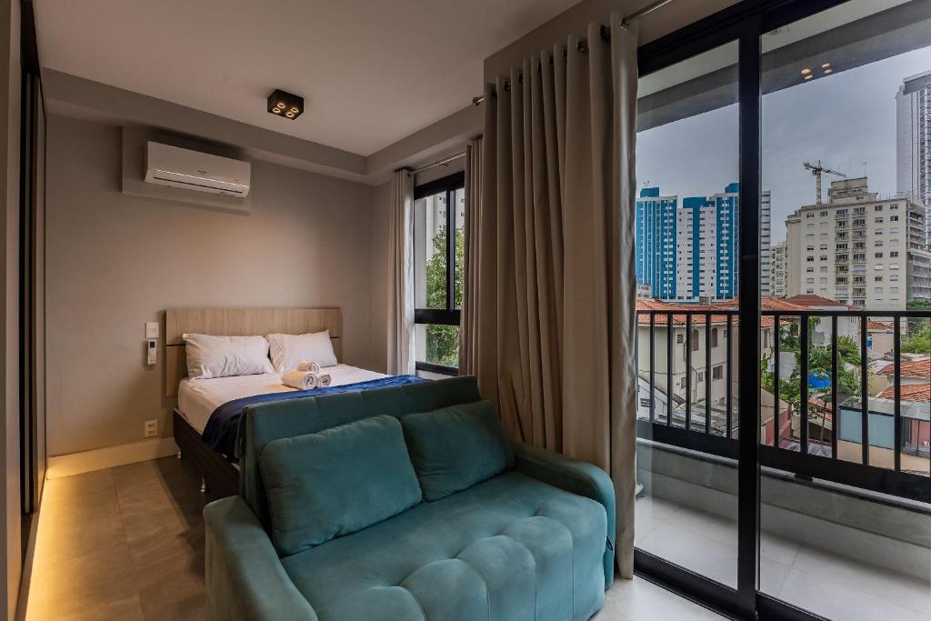 une chambre avec un lit, un canapé et une fenêtre dans l'établissement Studios Vila Madalena com Ar condicionado | Delfhy, à São Paulo