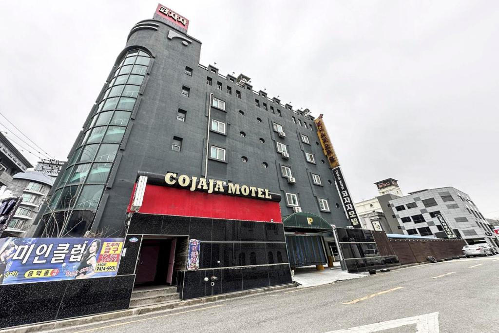 a black building with a red sign on it at 전주 코자자모텔 