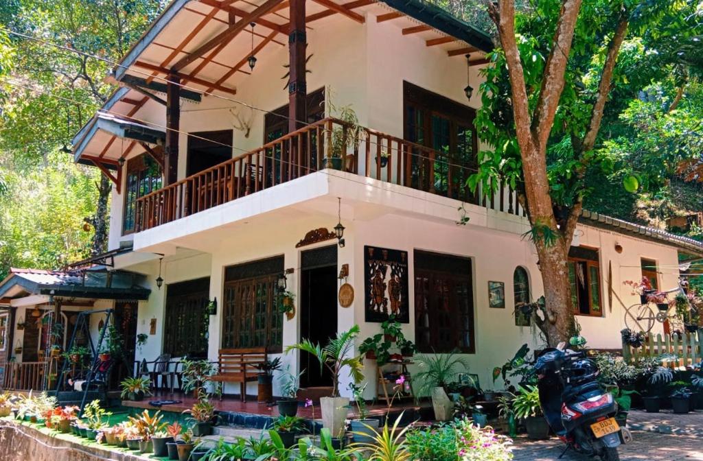 a house with a balcony and a tree at Villa25 Homestay free pick up from the centre in Kandy