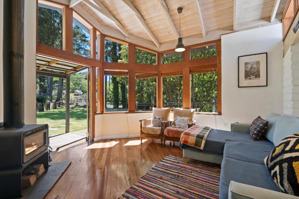 Una sala de estar con un sofá azul y una chimenea. en The Mud Brick House, en Leura