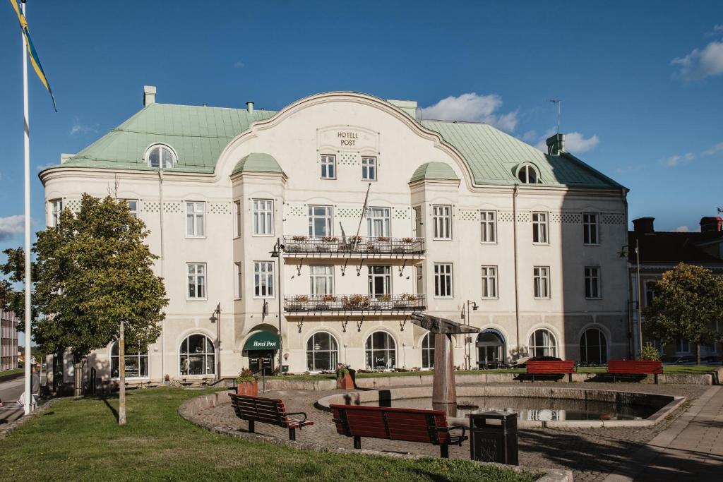 un gran edificio blanco con techo verde en Home Hotel Post, en Oskarshamn