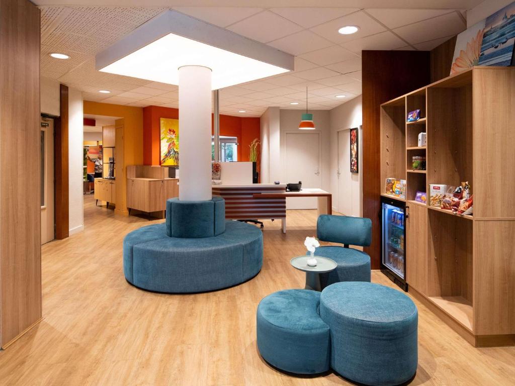 a lobby with two blue stools and a table and chairs at Adagio Access Lyon Centre Université in Lyon
