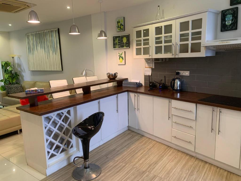 eine Küche mit weißen Schränken und einem schwarzen Stuhl in der Unterkunft Crown Luxury Apartment 2 Bed Room Apartment in Colombo
