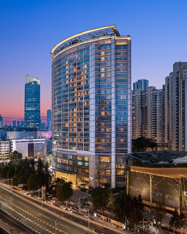 a tall building with many windows in a city at New World Wuhan Hotel in Wuhan