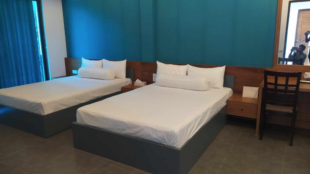due letti in una stanza con pareti blu di Aristocrat Resort Purbachal a Pānjora