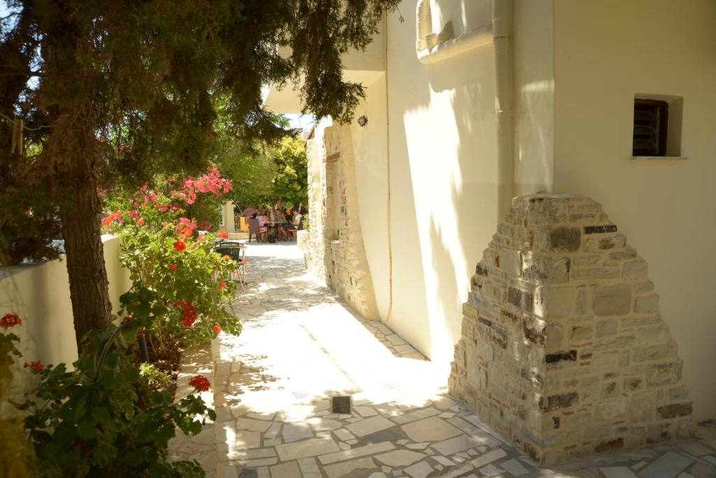 a narrow alley with flowers and a building at Villa Sylvia in Matala