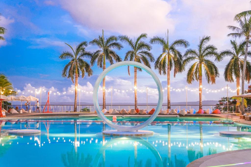una piscina con palme e un cartello al centro di Coral Ocean Resort a Saipan