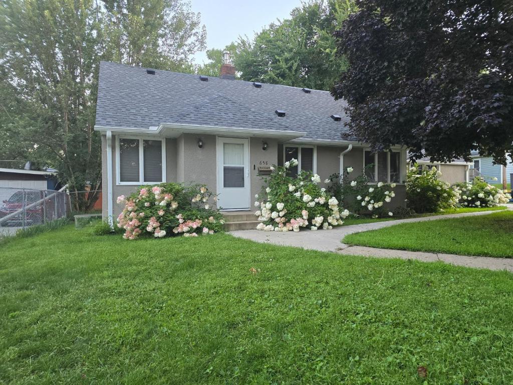 a small house with flowers in the yard at Spacious and Cozy 4-Bedroom Home in the heart of MSP in Saint Paul