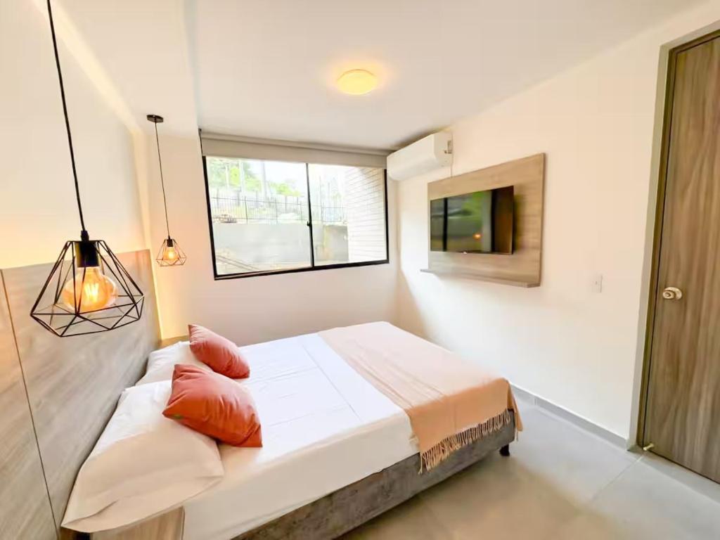 a bedroom with a bed and a window and a television at Confort total 2 Habitaciones, AC y excelente ubicación in Floridablanca