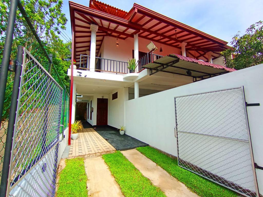 a house with a gate and a fence at Villa Piore in Mirissa