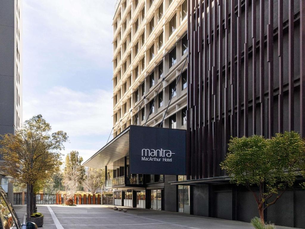 Un edificio con un cartel al costado. en Mantra MacArthur Hotel, en Canberra