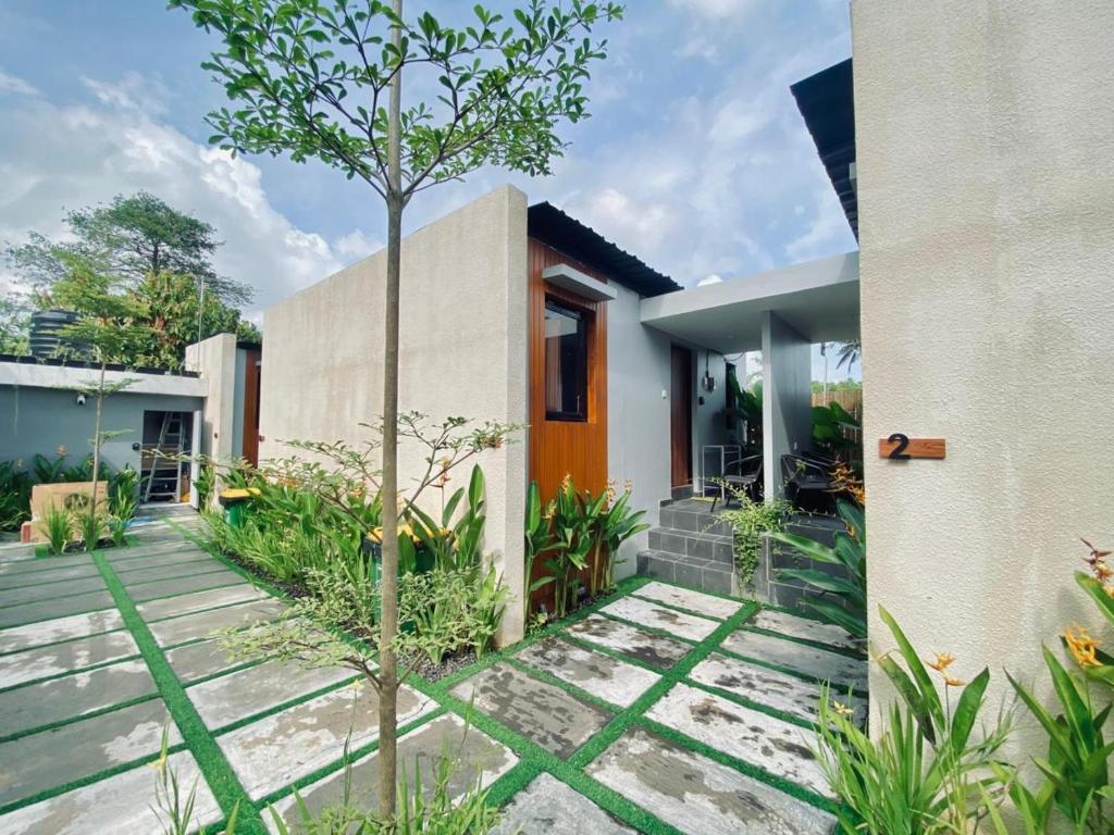 a house with a courtyard with a tree at Andewi Cabin in Sempidi