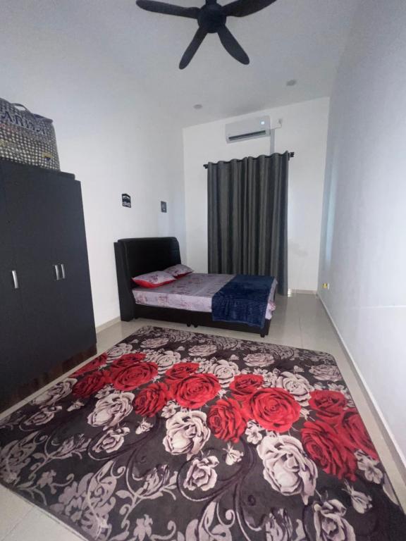 a bedroom with a bed with red roses on a carpet at HASYA Guesthouse Seri Iskandar in Seri Iskandar