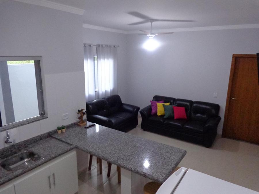eine Küche und ein Wohnzimmer mit einem Sofa und einem Tisch in der Unterkunft Casas para temporada em Bonito in Bonito