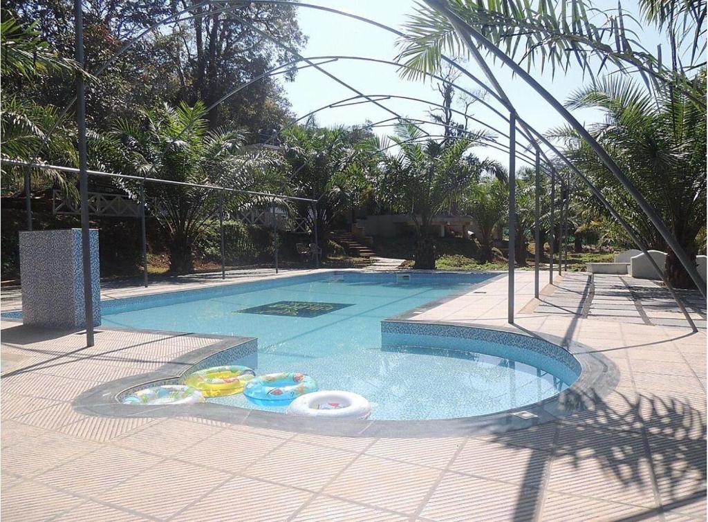 a swimming pool with two inflatable balls in it at Vantara jungle stay in Potolai