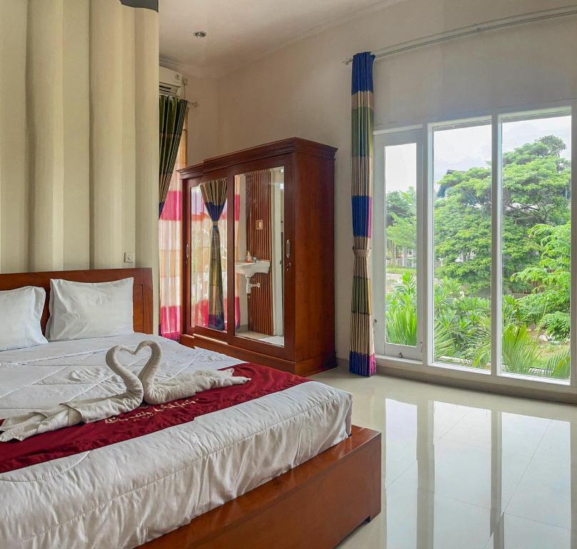 a bedroom with a bed with a swan on it at Omah Ulfah Homestay in Banyuwangi