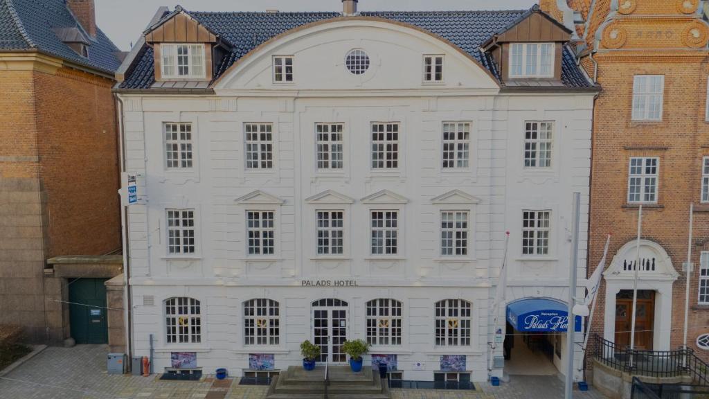 a large white building with a roof at Palads Hotel in Viborg