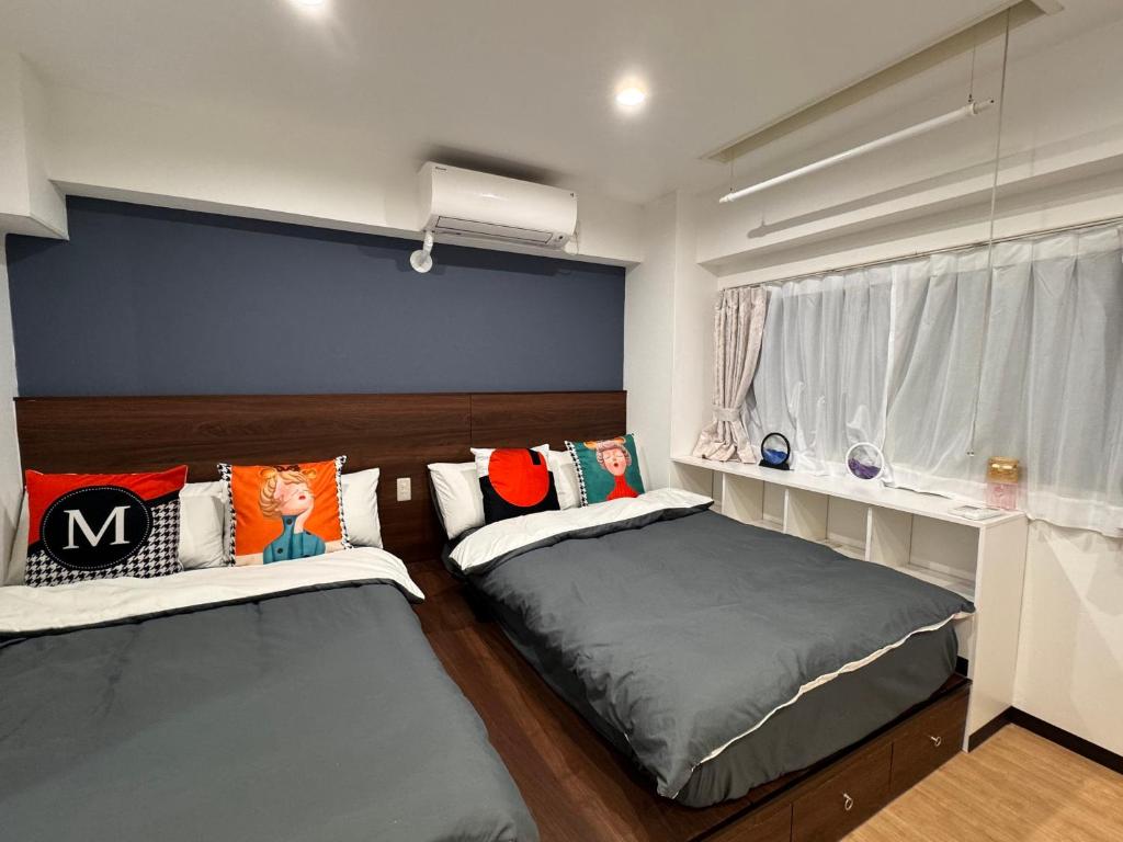 a bedroom with two beds and a window at 四季安々2号店 in Kawaguchi