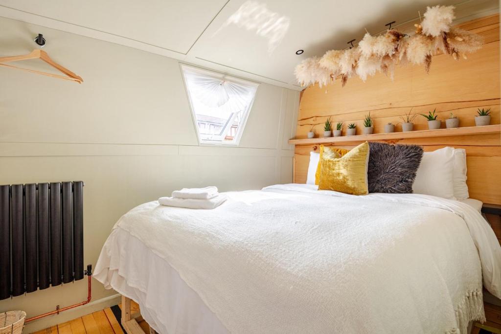 a bedroom with a large bed with white sheets at The Floating Terrarium in London