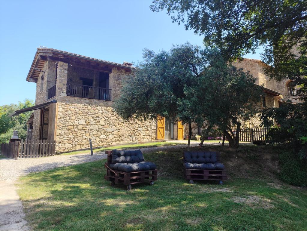 two chairs sitting in the grass in front of a building at Casa rural Ca l'Antón in Sant Miquel de Campmajor