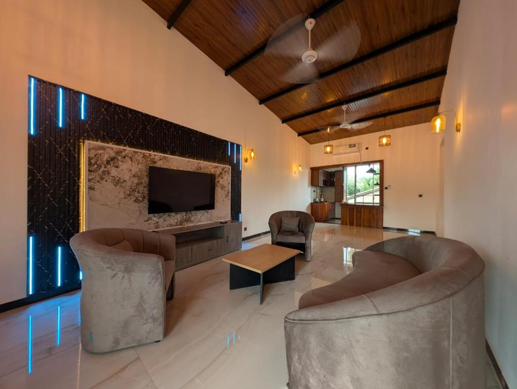 een woonkamer met twee stoelen en een open haard bij Kaveen Homes in Mount Lavinia