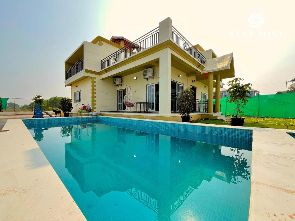a house with a swimming pool in front of it at Staymist - Pool and Pause Villa in Nagaon