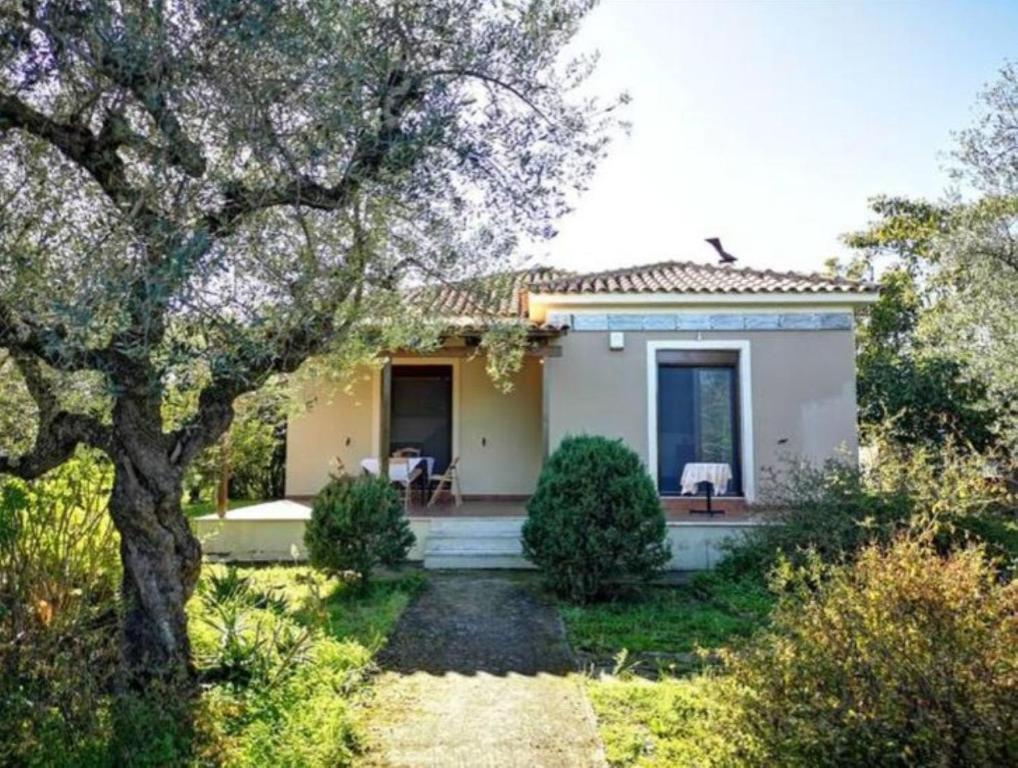 a small white house with a tree in the yard at Villa del Alma in Planos