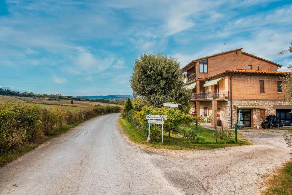 an old house on the side of a dirt road at Agriturismo Osea in Monteriggioni