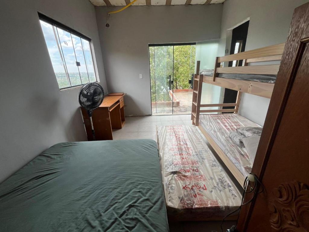 - une chambre avec des lits superposés, un bureau et une fenêtre dans l'établissement Casa no Lago em Corumbá 4, à Alexânia