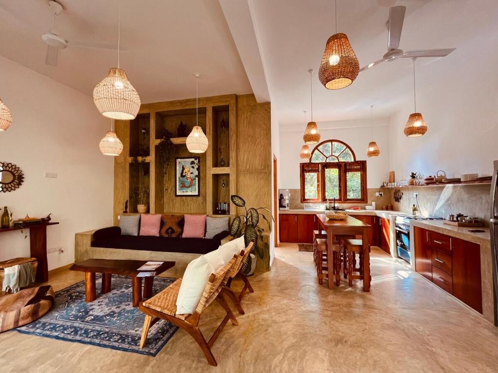 a kitchen and living room with a couch and a table at La Sirena Villa in Talpe