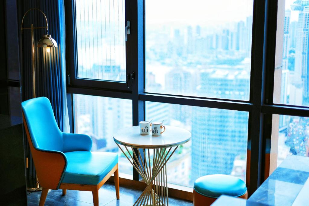 a room with a table and a chair and a window at VKing High-Altitude River View Hotel in Nan'an