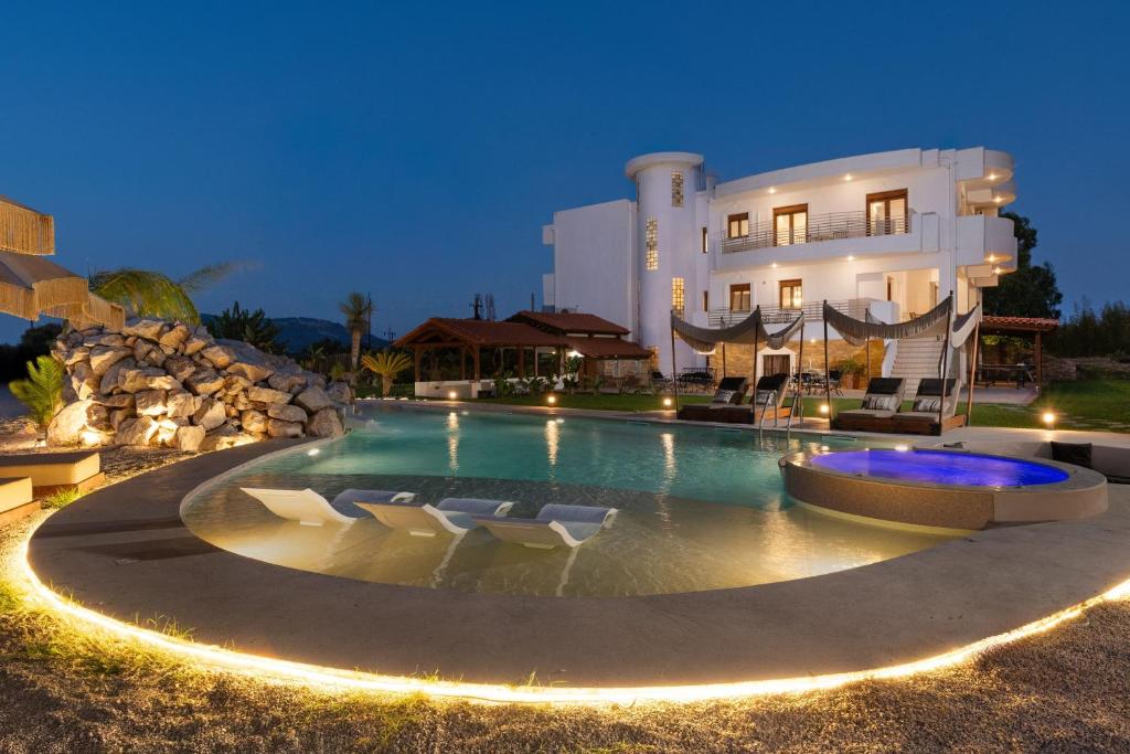 a swimming pool in front of a large building at Vento Estivo Mansion in Pastida