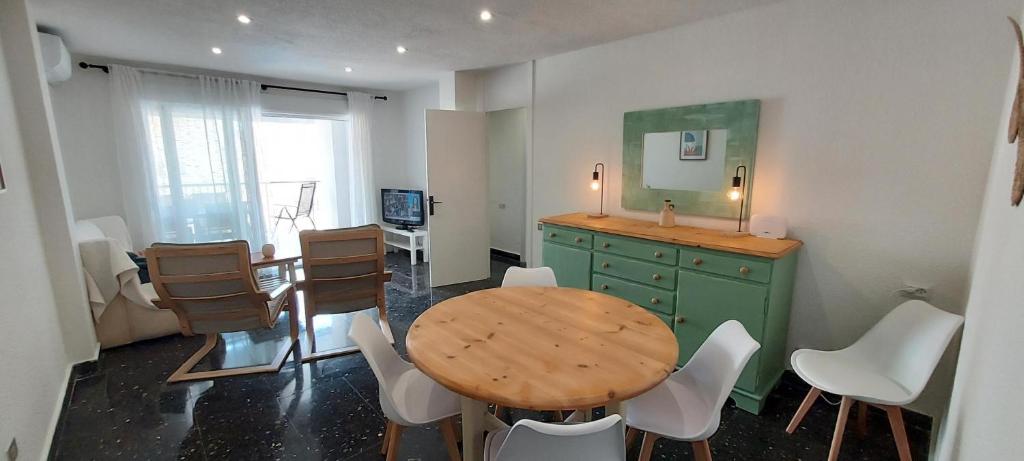 een eetkamer met een houten tafel en witte stoelen bij Mar 4 en Santa Pola in Santa Pola