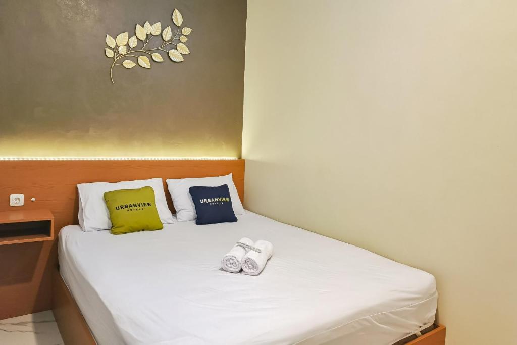 a small bedroom with a bed with two pillows at Urbanview Hotel JD Luxury Brebes in Banjararja