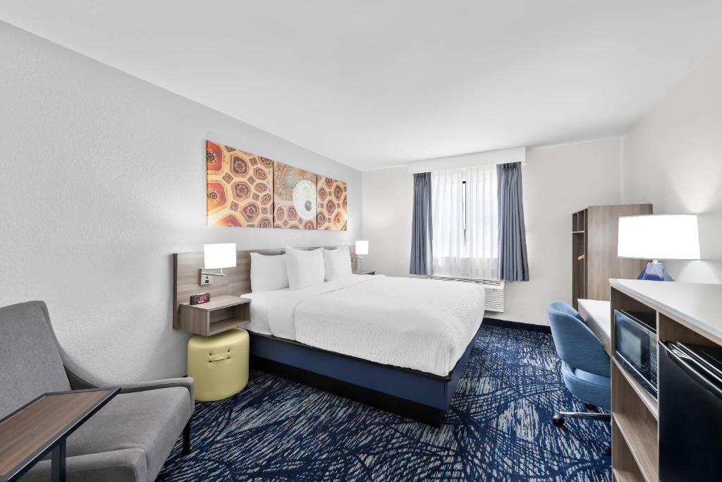 a large hotel room with a bed and a couch at Clarion Pointe in Shreveport