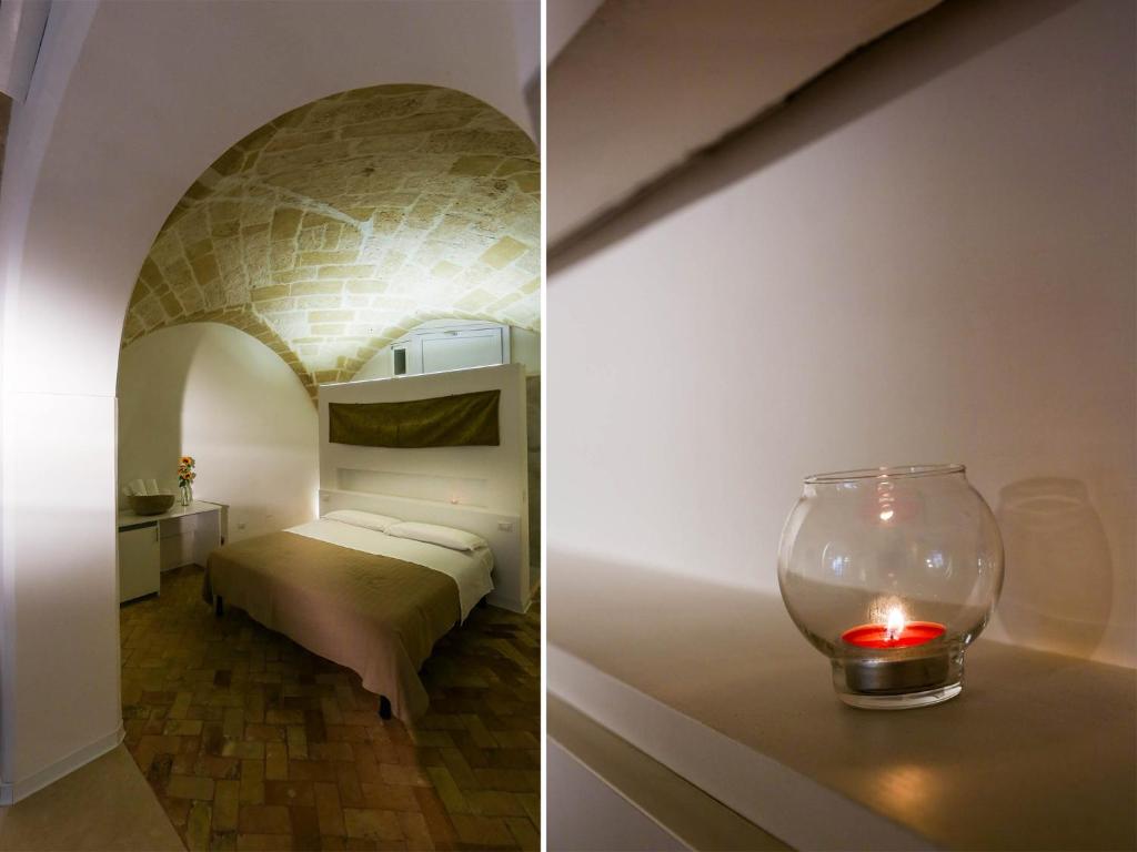 una habitación con una cama y una vela sobre una mesa en La casa del nonno, en Matera